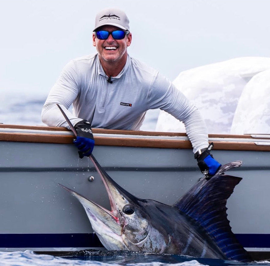 Angler on boat holding large marlin fish during Sportfish Galapagos Expeditions, Ecuador fishing trip.