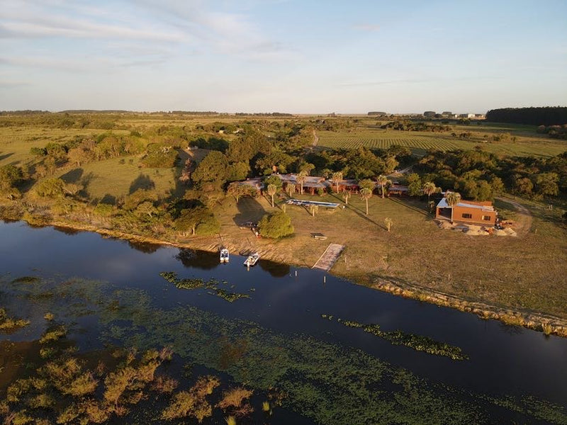 Don Joaquin River Lodge by Blackbone Outfitters showcasing the rustic lodge exterior and scenic river backdrop.