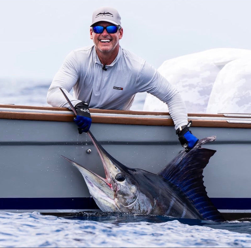 Angler on boat holding large marlin fish during Sportfish Galapagos Expeditions, Ecuador fishing trip.